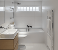 All white bathroom with bathtub, shower, toilet, sink, cabinet, mirror, radiator, windows