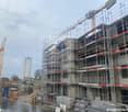 high-rise building under construction with scaffolding and cranes