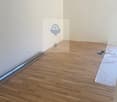 Empty room, white walls, hardwood floor, power outlet