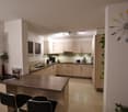 modern kitchen, wooden countertops, kitchen island, cabinets, tiled floor, wall mounted appliances