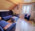 living room with wooden floor, blue couches, coffee table, chair, TV, radiator, wooden ceiling