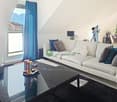 white sofa, black coffee table, large window, blue curtains, decorative items, telescope, potted plant