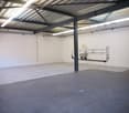Large open space, white walls, metallic ceiling, concrete floor, metal column, plumbing fixtures