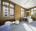 Large wooden windows, gray carpet, white desk, modern furniture, natural lighting