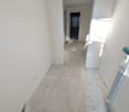 empty hallway with white walls and concrete floor