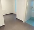 empty room with white walls, tiled floor, glass door, white door, bathroom inside door