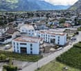 Construction of a residential building with solar panels on the roof, located in a mountainous area.