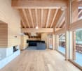 open space with wooden ceiling and walls, fireplace, kitchen island with sink and faucet, glass doors, wooden floor