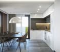 Dining table with chairs, modern white kitchen, large windows