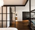 modern interior, wooden floor, glass walls, white walls, large windows, couch, table, chairs, kitchen, sink, faucet, cabinet, mirror, toilet