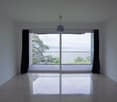 empty room, sliding glass doors, balcony, tiled floor, white walls, view of the sea