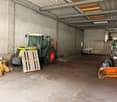 Empty garage with a tractor, wooden pallet, and other items