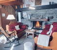 Carpeted floor, brick fireplace, wooden couch, rocking chair, coffee table, lamp, wooden stairs