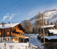 wooden chalet, snow covered, chimneys, balcony, mountain view