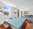 Dining area with large window, fireplace, dining table, chairs, large window with view of the mountains, couch