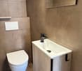 modern style bathroom, rectangular ceramic tiles, white toilet, rectangular white sink, grey wall