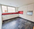 kitchen, white cabinets, red counter top, black tile flooring, window, stainless steel sink, faucet, oven