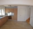 empty kitchen with wooden cabinets, stainless steel stove, dishwasher, wooden steps