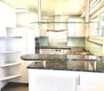 Modern kitchen, white cabinets, granite countertop, glass shelves, gas stove, dishwasher, washing machine, double ovens, sink