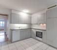Modern kitchen with white tiled floor, gray cabinetry, dishwasher, washing machine, sink, stove, oven, ceiling lamp