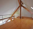 Attic room, wooden beams, wooden flooring, metal railing, skylights