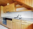 granite countertops, wooden cabinets, dishwasher, private washing machine, gas stove, sink, faucet, ceiling with wooden beams
