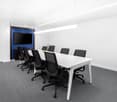 large meeting room, modern desk, chairs, television, plain walls, gray carpet