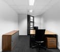 empty office with a desk, chairs, and cabinets, white walls, wooden floor, built-in window