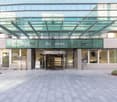 Modern building with glass walls, multiple floors, revolving entrance, well-kept entrance