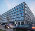 modern office building, gray walls, glass windows, car parking in front