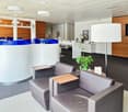 leather chairs, white desk, blue counter, white lamp, potted plant, carpet