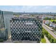 modern office building, glass facade, multiple floors, located in a city landscape
