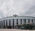 Modern building, glass facade, arched roof, entrance with lion statues, office building