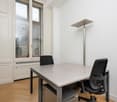 empty room, 2 office chairs, grey table, white walls, hardwood floor, window