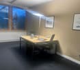Office room with desk, chairs, radiator, pictures, lamp, and electrical outlets