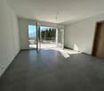 empty room with grey tiled floor, white walls, sliding glass doors, balcony, outside view with mountains