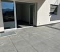 Glass sliding doors, tiled balcony, white exterior walls, window with blinds