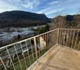 balcony, metal railing, overlooking valley with mountains and river
