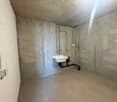 small room, concrete walls, white sink, tiled floor