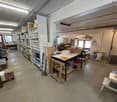 Storage room with shelves, boxes, a desk, a window with a view, and tools