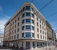 a multi-story building with many windows, name spaces, ground floor has stores