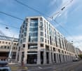 multi story building, office space, glass windows, arched entrance, street in front