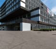 modern office building, black and white exterior, large windows, glass doors, parking lot