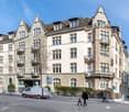 5-story building, stone facade, multiple balconies, modern architecture
