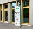 modern building exterior with glass doors, signage for offices, Sapori's restaurant, yellow door handles