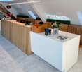 Wooden counters, reception desk, white surfaces, books, potted plants, modern furniture