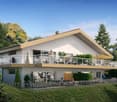 Two-story modern house with a large balcony/terrace, surrounded by lush greenery and trees. The house has a sleek, angular design with large windows and a neutral color scheme. There are people visible on the balcony, suggesting it is a residential proper