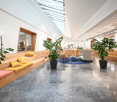 Lobby with marble flooring, skylight, various potted plants, comfortable seating area