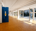 empty hallway, wooden flooring, white walls, blue door, open doors leading to exterior