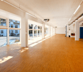 large windows, wooden floor, AC unit mounted on the wall, wide open space